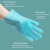 A hand wearing a light blue silicone glove with a dense tooth needle texture, used for pet grooming.