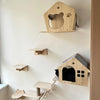 Árbol de gato de madera de varias capas y poste para rascar montado en una pared blanca.