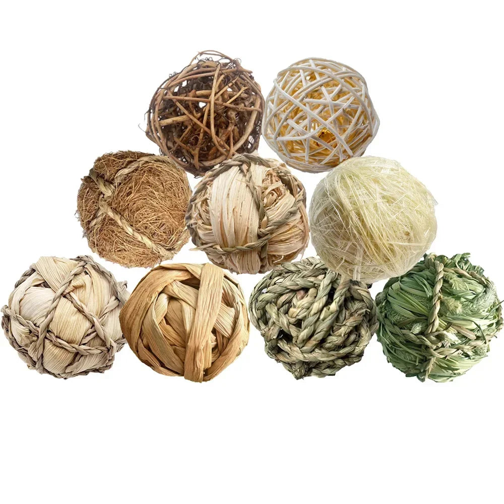 A collection of natural grass chew balls in various shades including brown, beige, yellow, and green.