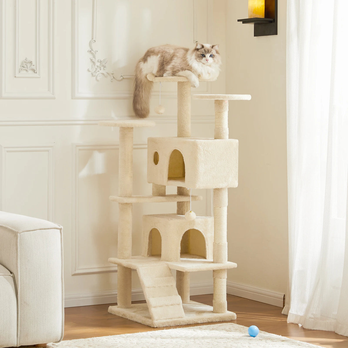 A light beige cat tree tower with four tiers, featuring cozy condos and sisal scratching posts, placed in a bright room.