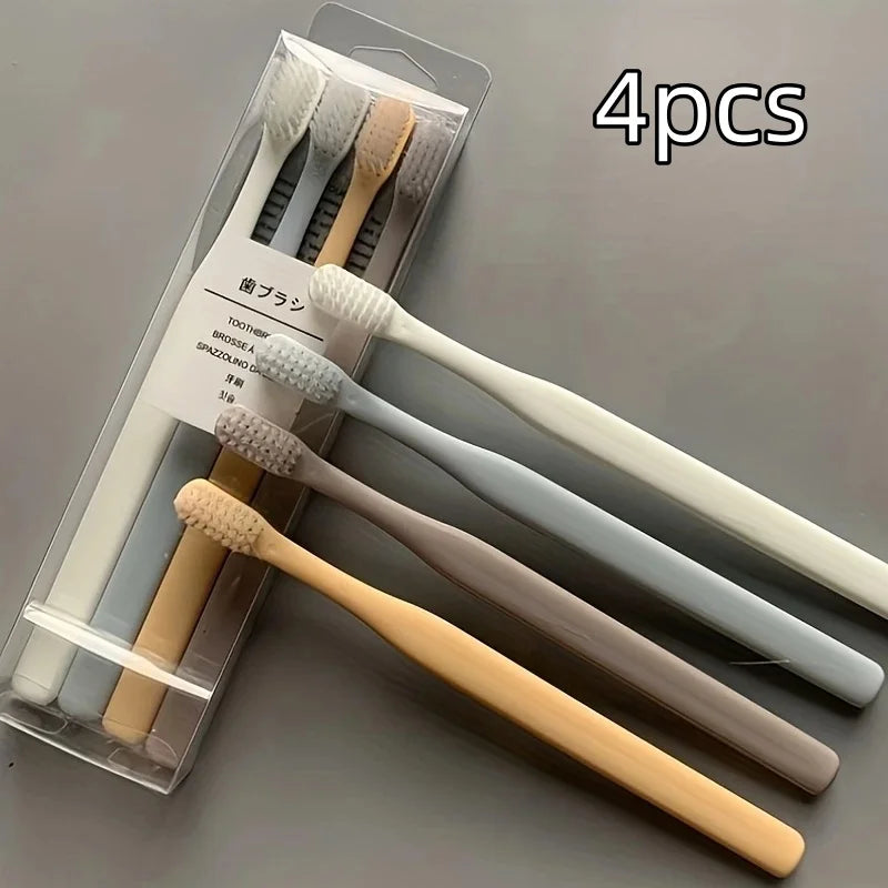 A set of four soft-bristle travel toothbrushes in various colors packaged in a clear plastic case.