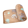A rolled-up, tan pet blanket with light blue paw prints is shown.