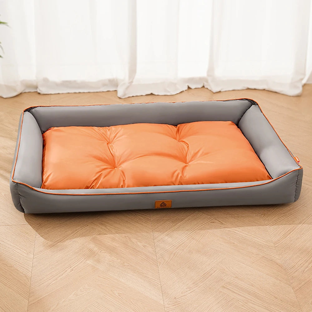 A gray pet sofa bed with an orange corduroy cushion placed on a light wooden floor.