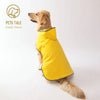 A bright yellow all-weather dual-sided dog raincoat being worn by a golden retriever.