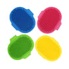 Three silicone pet grooming brushes in blue, pink, green, and yellow.