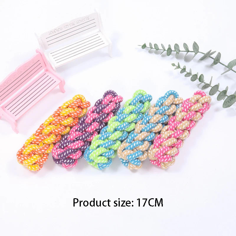 Colorful braided cotton rope dog chew toys and a pink plastic item are displayed on a white background.