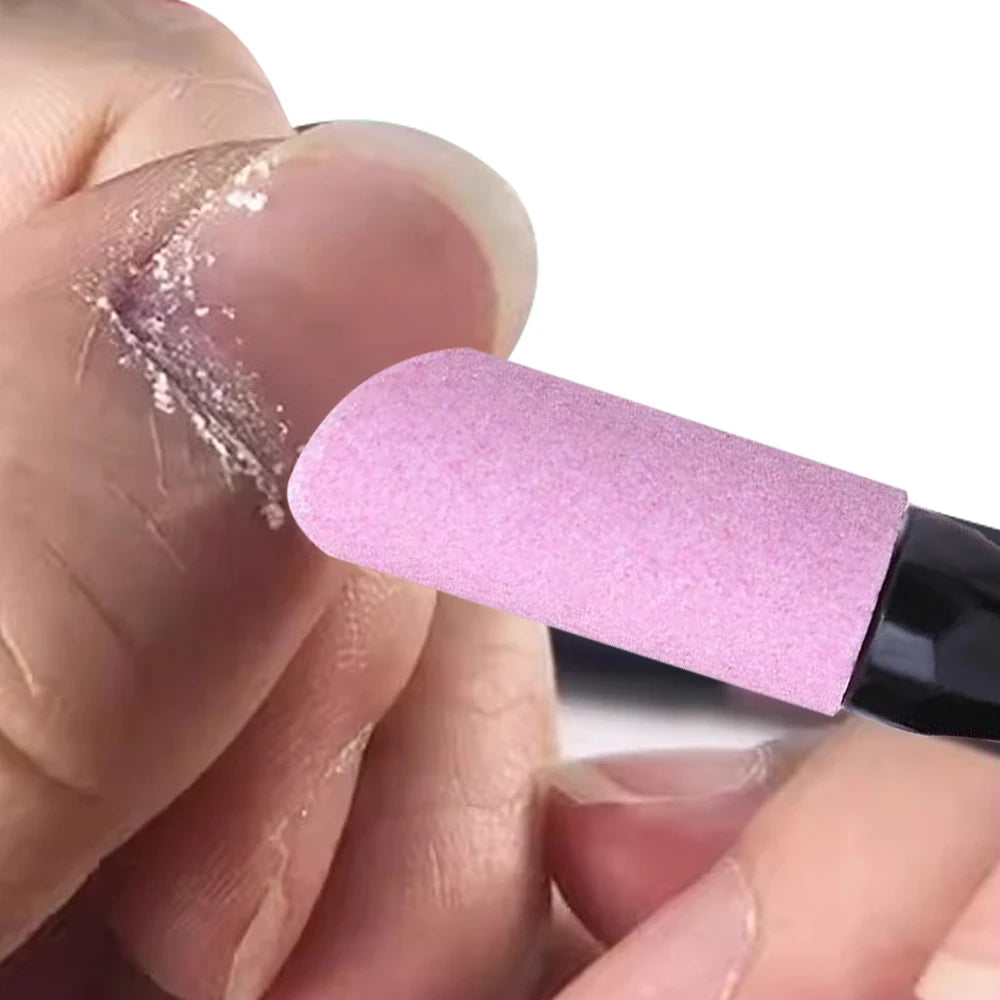 A hand applies a pink nail file and cuticle remover tool to a fingernail.