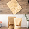 Several reusable kraft paper zipper bags filled with food items are displayed on a wooden surface.
