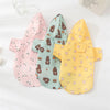 A set of three cartoon printed dog raincoats in pink, mint green, and yellow for small breeds.
