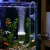 A clear glass aquarium setup showing aquatic plants and an aquarium CO2 diffuser with a bubble counter attached by a suction 