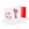 White framed art showing a reddish handprint and footprint on a white background.