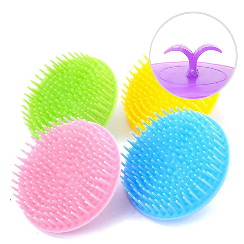 A collection of four silicone hair and scalp massage brushes in green, yellow, pink, and blue.