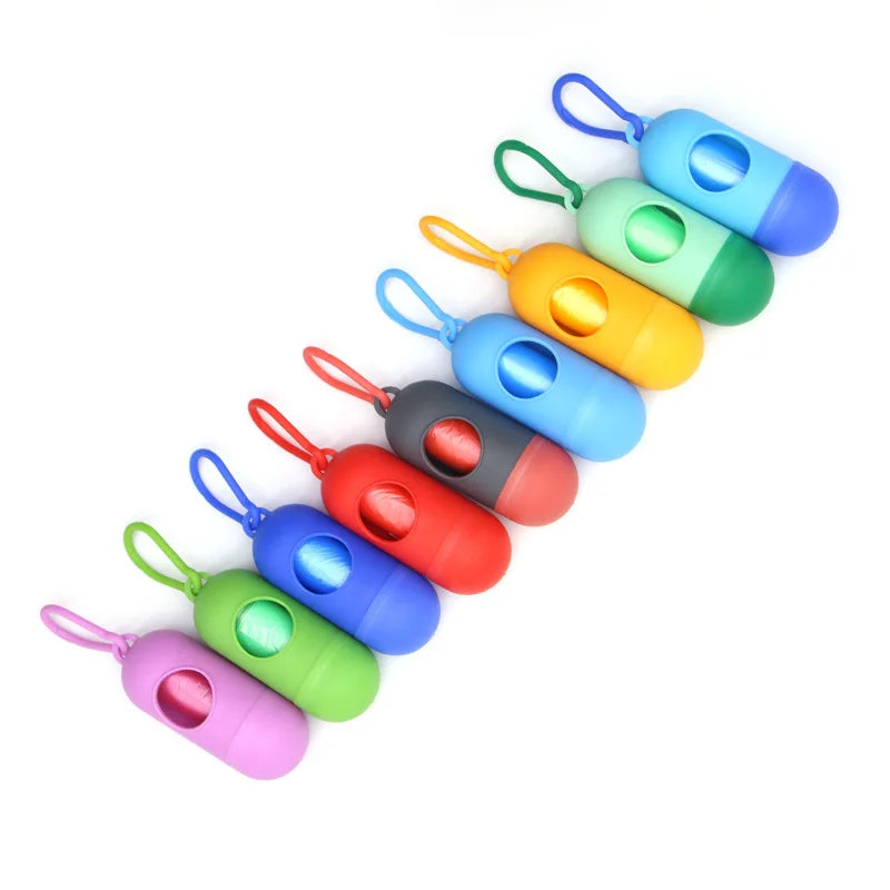 A line of colorful capsule-shaped dog poop bag dispensers with carabiner clips.