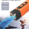 An orange ultrasonic dog repellent device emits a blue frequency wave towards a small dog.