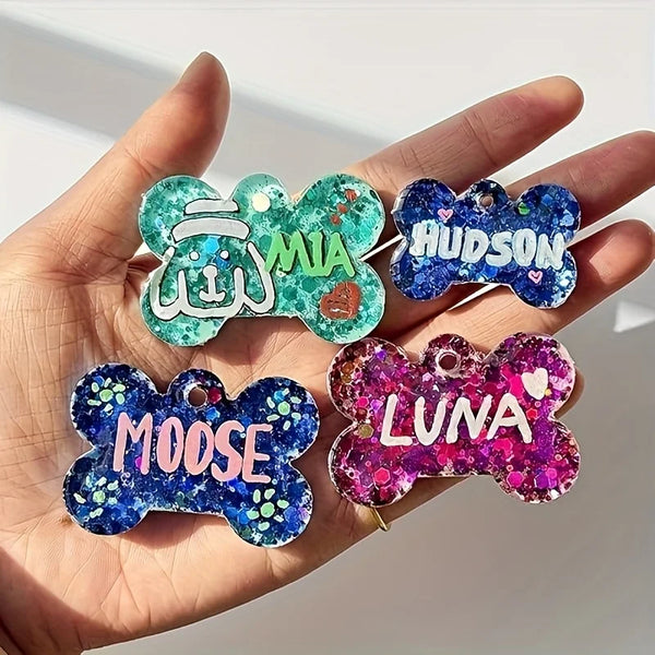 Hand holding four silicone dog bone molds for resin casting featuring names like Mia, Hudson, Moose, and Luna