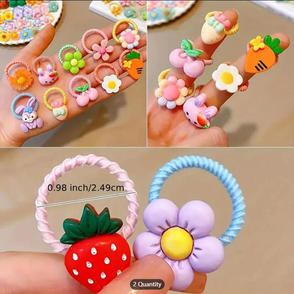 Eine Hand hält mehrere bunte Haarspangen in Form von Blumen und Erdbeeren.