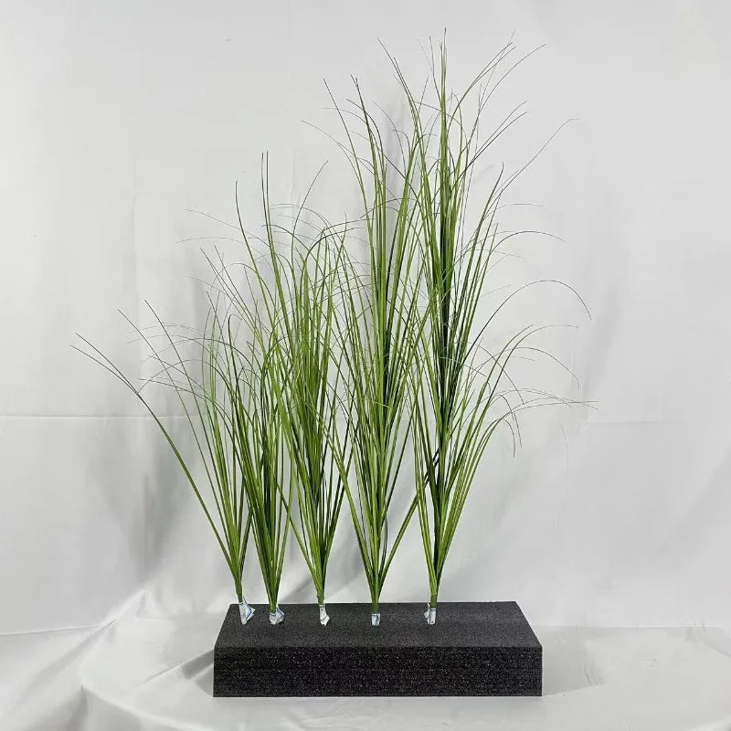 Trois brins d'oignon vert miniature décor de jardin debout sur une base gris foncé.