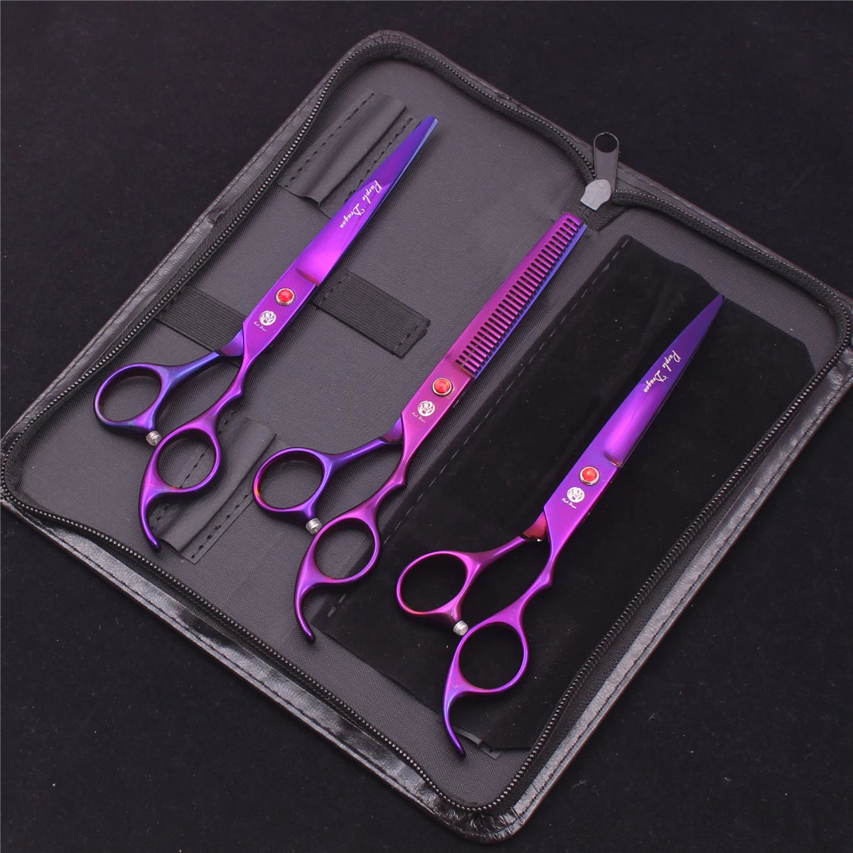 A set of professional stainless steel pet grooming scissors in purple and silver are displayed inside a black zippered case.
