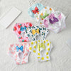 A collection of reusable dog physiological pants in various floral and colorful patterns are displayed on a white surface.