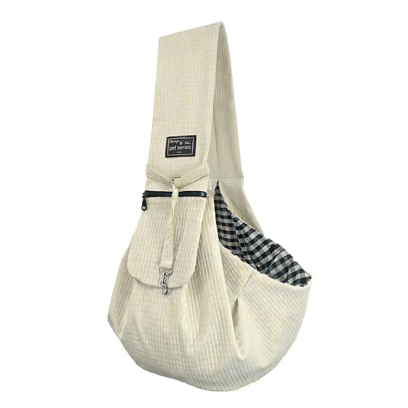 A beige quilted crossbody pet carrier bag for dogs and cats with a checkered fabric detail.
