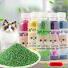 Eine Flasche natürliche Katzenstreu-Deodorierungskugeln neben einem Haufen grüner Streu und einer Katze.