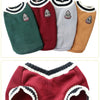 A collection of knitted vests for small dogs in various colors including green, maroon, gray, and tan.