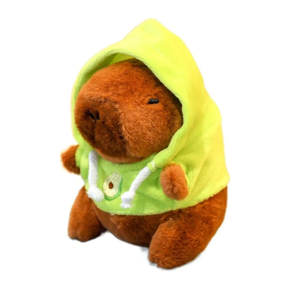 A brown capybara plush doll wearing a lime green hoodie with white wings.