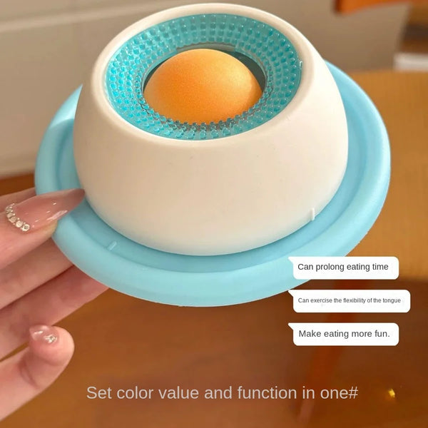 A white pet lick toy with a blue silicone lid is shown being held, designed to prolong eating time and make feeding fun.