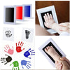 A collection of baby handprints and footprints in various colors on white paper, demonstrating a keepsake kit.