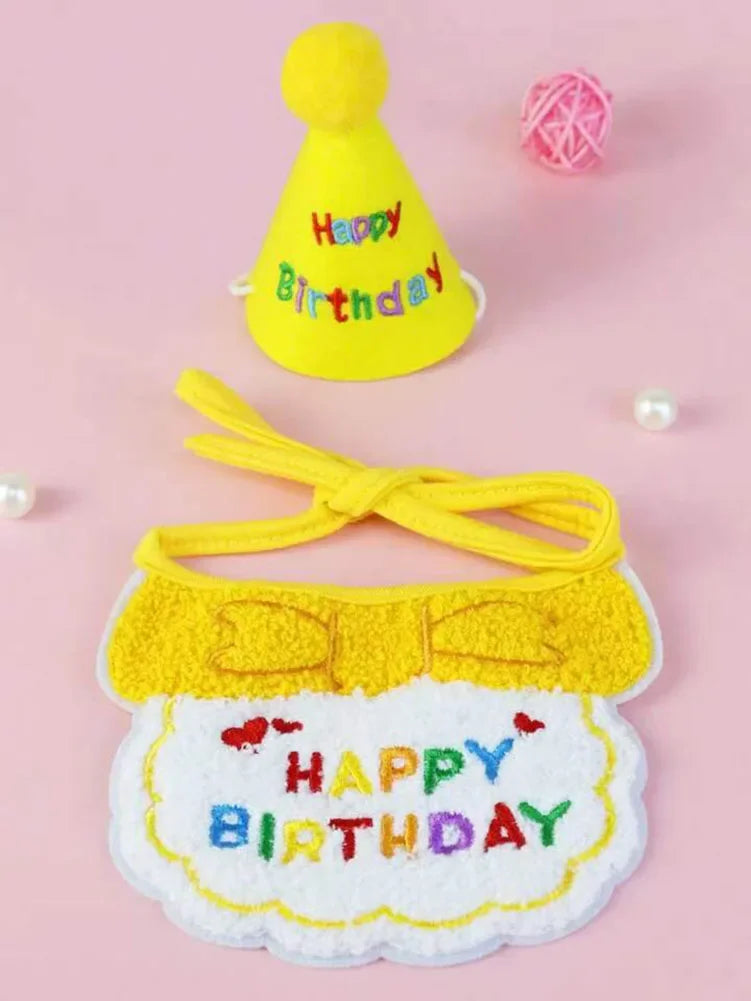 Un ensemble de bibs et chapeaux de fête jaunes avec un pompon jaune et du texte brodé sur un fond rose.