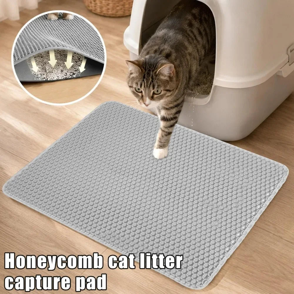 A gray honeycomb cat litter capture pad is shown next to a white litter box with a cat peering into it.