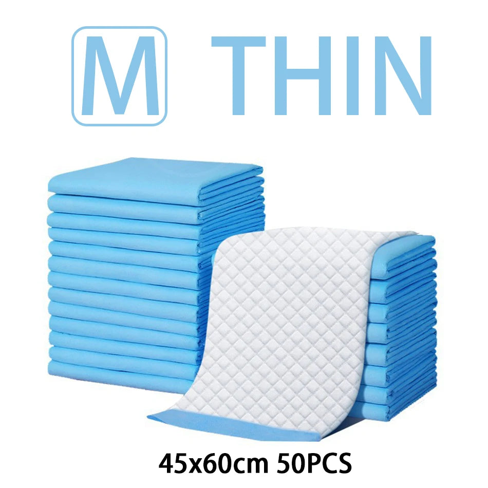 A stack of blue disposable absorbent dog diapers and one unfolded white diaper are shown.