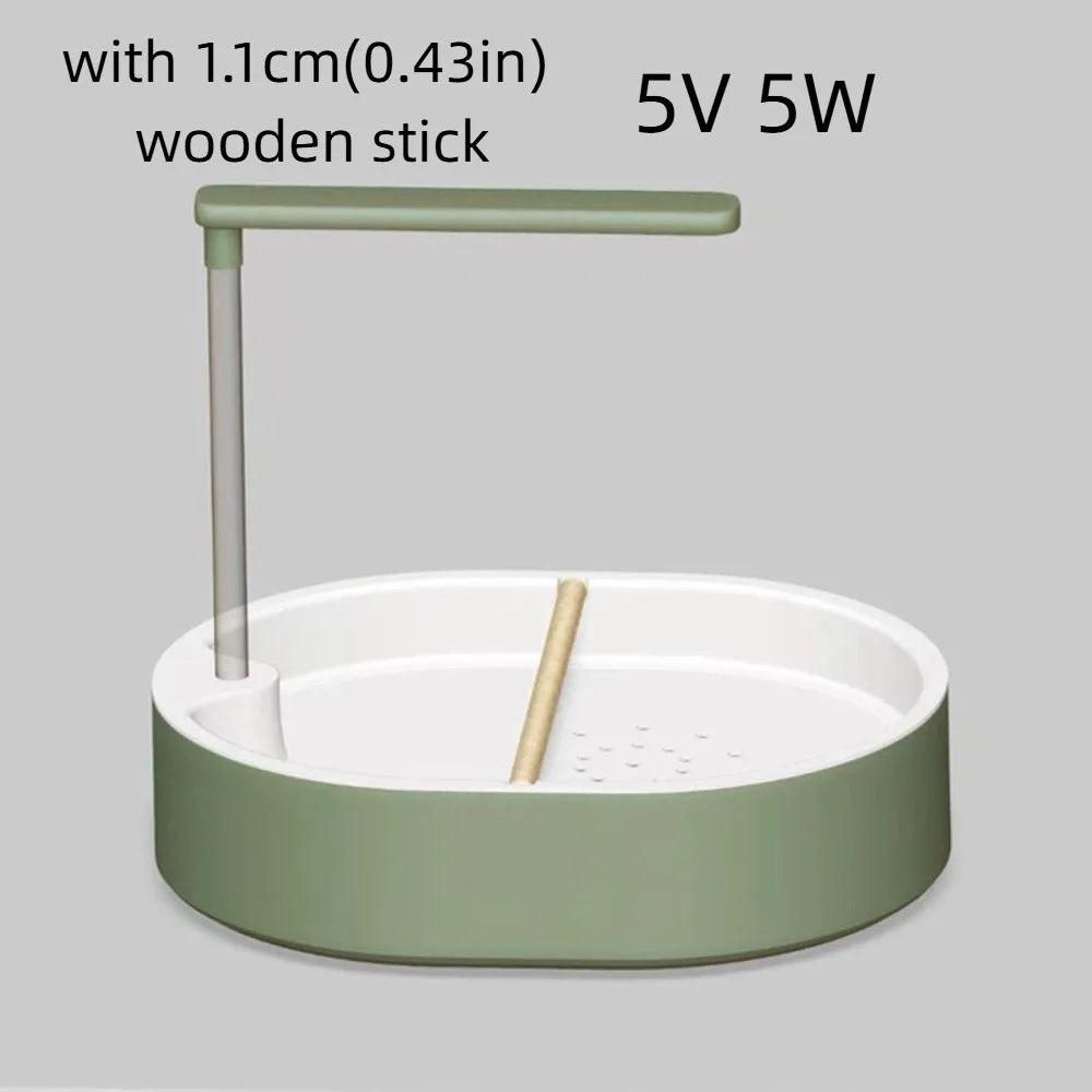 A light green automatic bird bathtub with a resting stick and power specifications 5V 5W