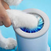 A hand is cleaning a white pet paw inside a white cup, which is part of an automatic pet paw cleaner system.