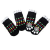 A pack of four black anti-slip pet socks with colorful patterns for dog and cat protection