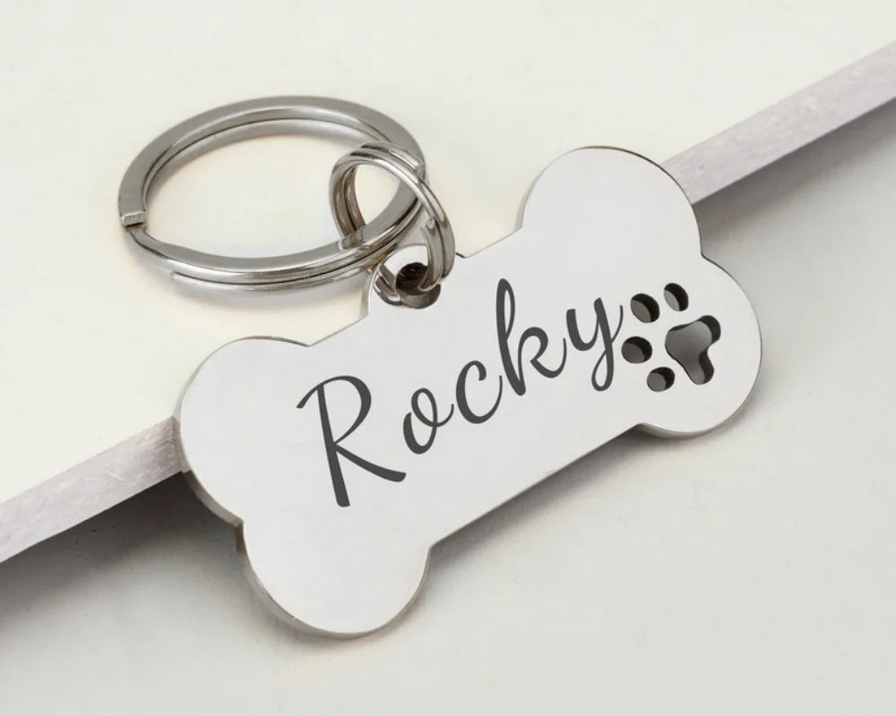 Silver bone-shaped stainless steel dog ID tag engraved with the name Rocky