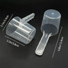 Transparent pet measuring spoon with scale for dog and cat food, shown from above.