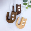 A set of wooden pet whisker collector vases with glass tubes and small white discs.