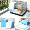 Blue pet training pads and a wire crate for small dogs are shown in various contexts.