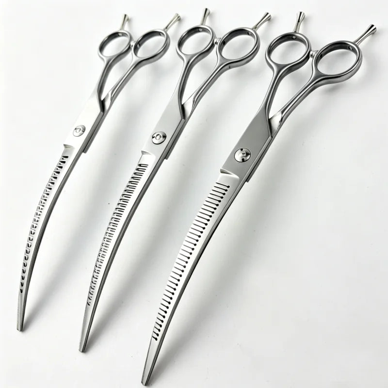 Ein Set silberner gebogener Haarscheren für Hunde, die auf einer weißen Oberfläche liegen.