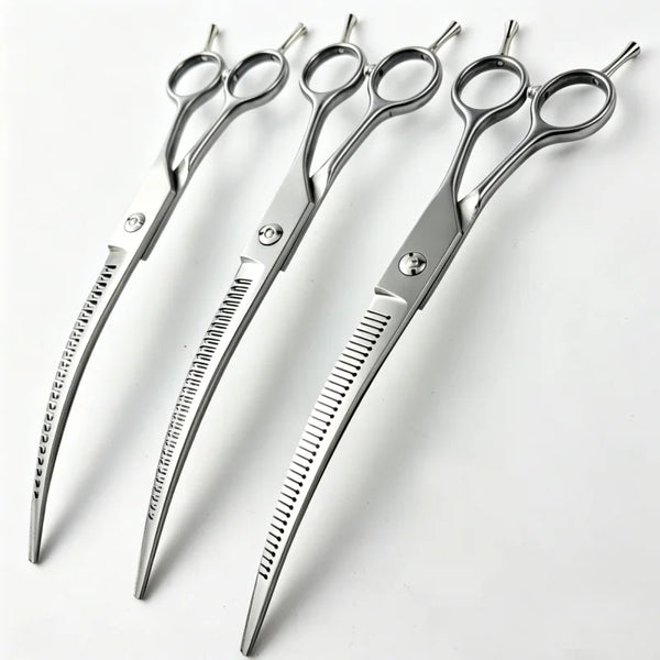A set of silver curved pet grooming scissors for dogs lying on a white surface.