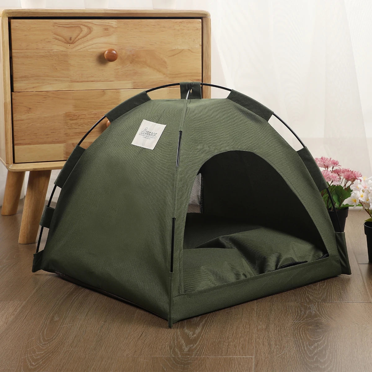 A dark olive green cozy pet tent bed for cats resting on a wooden floor.