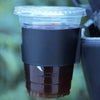 A portable vehicle drink holder filled with dark brown liquid, viewed from above.
