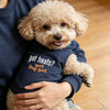 A person is holding a light brown poodle wearing a navy blue pet polo vest with the text got treats?