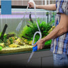 Une personne utilise une pompe de siphon pour nettoyer l'intérieur d'un aquarium.