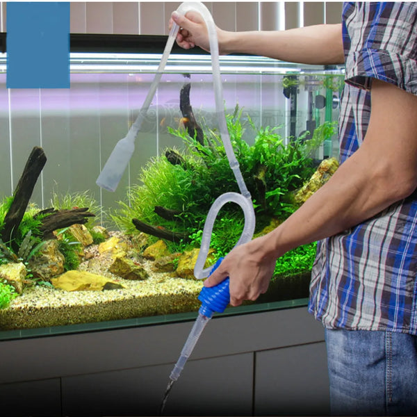 Une personne utilise une pompe de siphon pour nettoyer l'intérieur d'un aquarium.