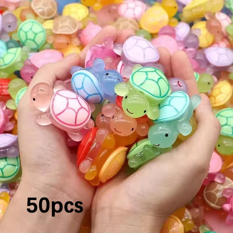 Une main tient une collection d'ornements de tortues en résine colorés et lumineux.