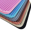 Pile de tapis pour litière imperméables colorés pour boîtes de chat aux tons rose, bleu, gris et marron.