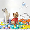 A gray cat and a small brown dog are interacting with colorful training buttons on a surface.