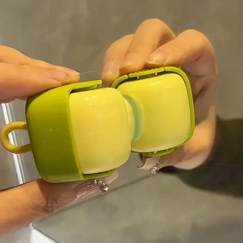A hand is holding a lime green portable lint roller with a yellow interior, demonstrating its use for pet hair removal.